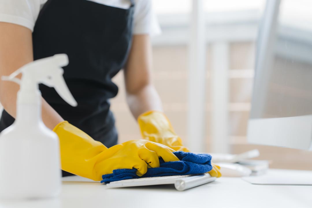 A gloved hand wiping a surface clean